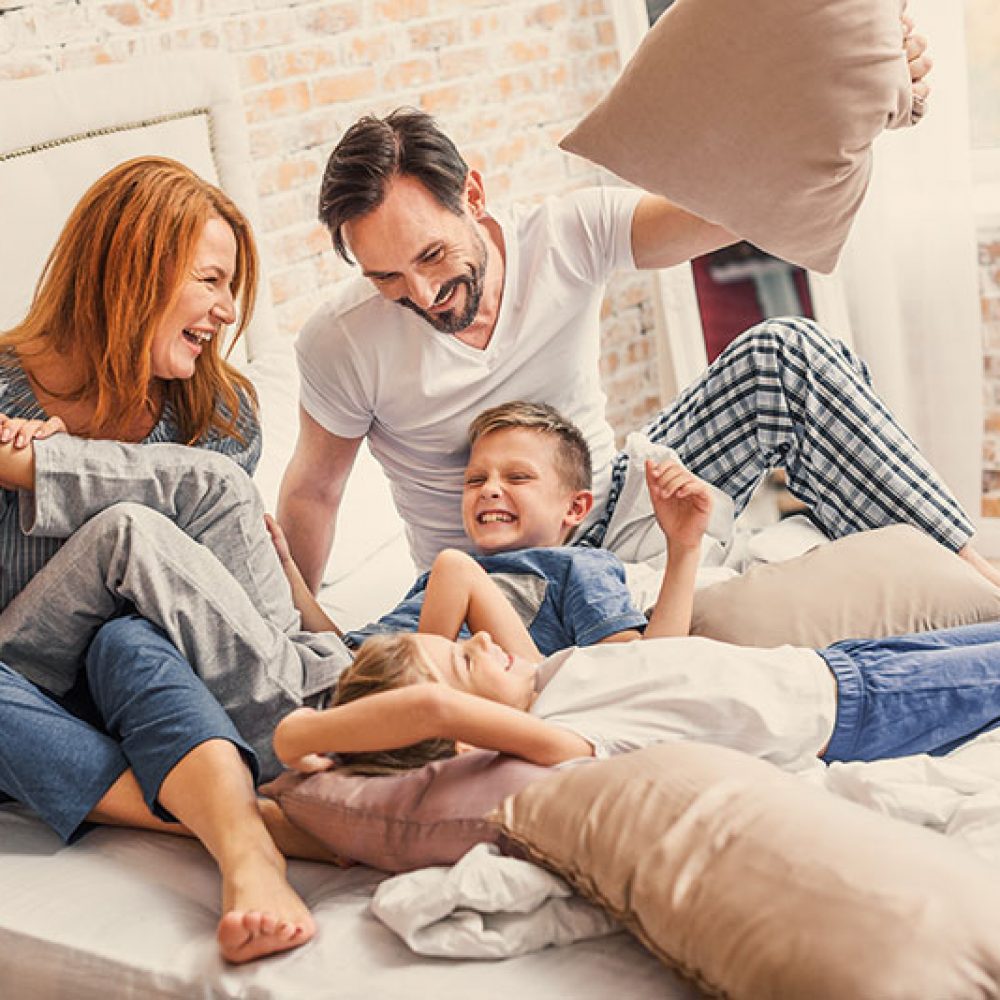 Glückliche Familie entspannt gemeinsam im Schlafzimmer eines Hauses